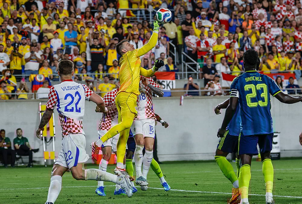 Croatia goalkeeper Dominik Livakovic, center, punches the ball away from the goal during the second half of an international friendly soccer game in Orlando, Florida.  - | Photo: AP/Kevin Kolczynski