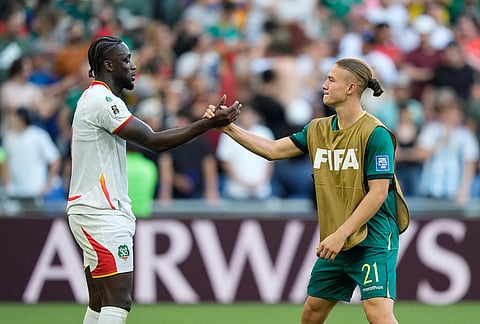 Suriname's Myenty Abena, left, and Bolivia's Lucas Macazaga shake hands after a World Cup playoff semifinal soccer match between Bolivia and Suriname in Monterrey, Mexico.