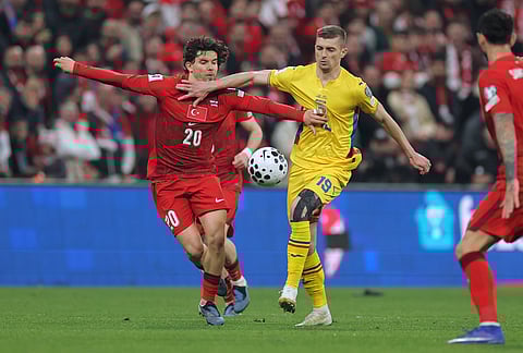 Turkey's Ferdi Kadioglu, left, vies for the ball with Romania's Florin Tanase during the 2026 World Cup playoff semifinal soccer match between Turkey and Romania, in Istanbul, Turkey, Thursday, March 26, 2026. (AP Photo)