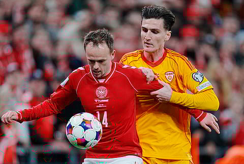 Denmark's Mikkel Damsgaard, left, and North Macedonia's Lirim Qamili in action during the World Cup playoff semifinal soccer match between Denmark and North Macedonia in Copenhagen.