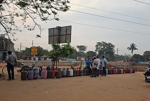 People wait with empty LPG cylinders to avail refilled ones amid ongoing supply crisis, in Bhubaneswar, Odisha.