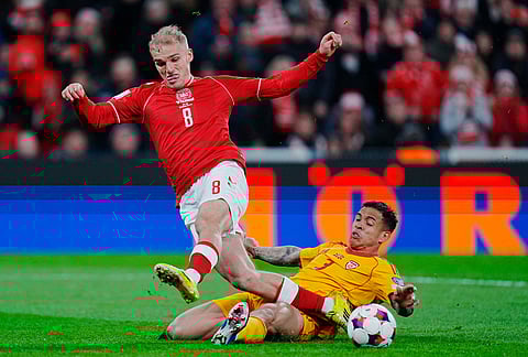 North Macedonia's Sebastian Herrera tackles Denmark's Gustav Isaksen during the World Cup playoff semifinal soccer match between Denmark and North Macedonia in Copenhagen.