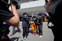 | Photo: AP/Eugene Hoshiko : McLaren driver Oscar Piastri of Australia gives autograph to fans after the first practice session of the Japanese Formula One Grand Prix in Suzuka, Japan.