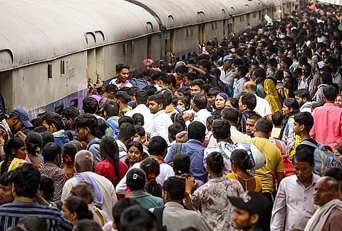 Passengers throng a railway station to board a train after the conclusion of 'Ram Navami' and ‘Chaiti Chhath’ festivals, in Patna.