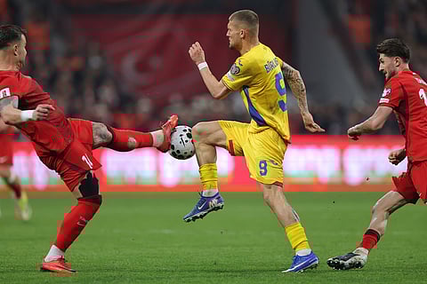 Romania's Daniel Birligea, center, vies for the ball with Turkey's Abdulkerim Bardakci during the 2026 World Cup playoff semifinal soccer match between Turkey and Romania, in Istanbul, Turkey.