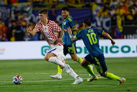 Croatia forward Andrej Kramaric (22) drives the ball by Colombia defender Jhon Lucumí (10) during the first half of an international friendly soccer game in Orlando, Florida.