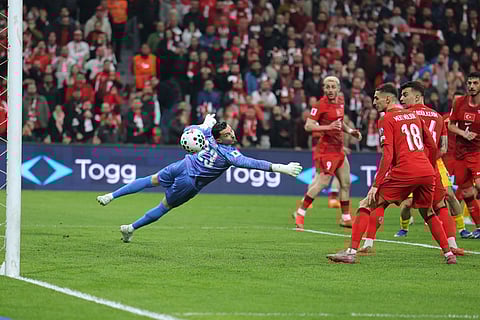 Turkey's goalkeeper Ugurcan Cakir, left, eyes the ball during the 2026 World Cup playoff semifinal soccer match between Turkey and Romania, in Istanbul, Turkey.