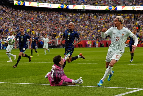 Hugo Ekitike of France scores his side's second goal past Brazilian goalkeeper Ederson during the international friendly soccer match between Brazil and France in Foxborough, Massachusetts.