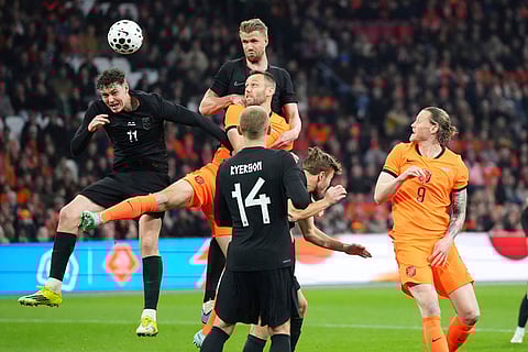 Netherlands' Teun Koopmeiners, centre, challenges for the ball with Norway's Jorgen Strand Larsen, left, and Kristoffer Ajer, top, during the international friendly soccer match between the Netherlands and Norway in Amsterdam, Netherlands.