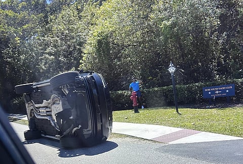 Golfer Tiger Woods stands by his overturned vehicle in Jupiter Island, Florida.