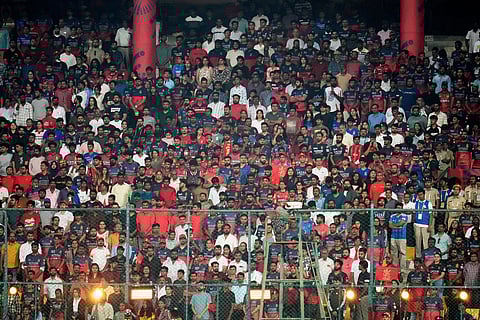 Spectators observe a minute's silence to pay tribute to 11 Royal Challengers Bengaluru fans who lost their lives in a stampede last year, before the start of the Indian Premier League cricket match between Royal Challengers Bengaluru and Sunrisers Hyderabad, in Bengaluru, India.