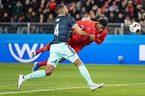 Switzerland's Breel Embolo, right, scores the second goal for Switzerland against Germany's Jonathan Tah, left, during an international friendly soccer match between Switzerland and Germany in Basel, Switzerland.