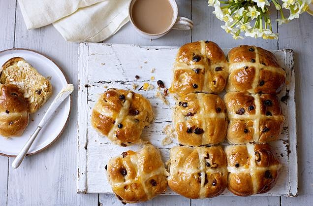 Hot cross buns with tea and spring flowers