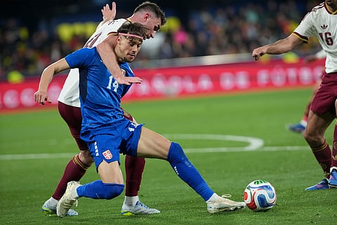 Serbia's Veljko Birmancevic, front, and Spain's Aymeric Laporte challenge for the ball during the international friendly soccer match between Spain and Serbia in Villarreal, Spain.