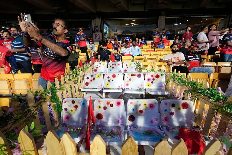 Flowers are placed on 11 seats kept at M Chinnaswamy Stadium as a tribute to eleven Royal Challengers Bengaluru fans who lost their lives in a stampede last year, as spectators wait for the Indian Premier League cricket match between Royal Challengers Bengaluru and Sunrisers Hyderabad to begin in Bengaluru, India. - Photo: AP/Aijaz Rahi