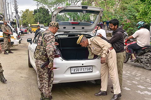 Security personnel check a vehicle as a safety measure ahead of the Assam Assembly elections, in Guwahati.