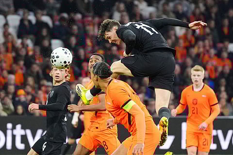 Norway's Jorgen Strand Larsen, top, and Netherlands' Virgil van Dijk, centre, challenge for the ball during the international friendly soccer match between the Netherlands and Norway in Amsterdam, Netherlands.