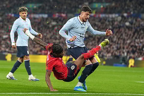 England's Noni Madueke, left, is challenged by Uruguay's Maximiliano Araujo during the international friendly soccer match between England and Uruguay in London.