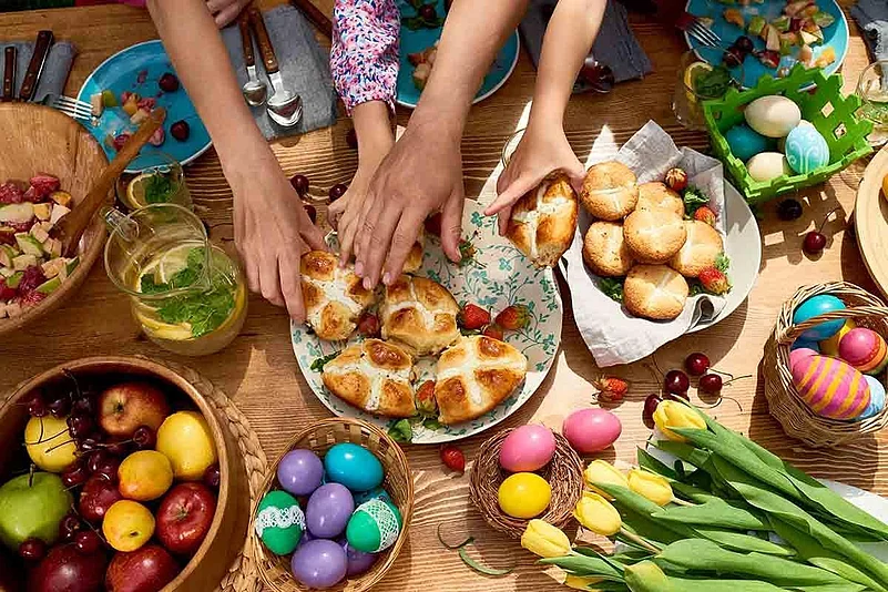 Easter table with hot cross buns and dyed eggs