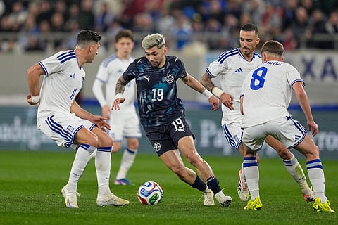 Paraguay's Julio Enciso, centre, challenges for the ball with Greece's Anastasios Bakasetas, left, and Greece's Christos Mouzakitis during the international friendly soccer match between Greece and Paraguay in Piraeus, Greece.