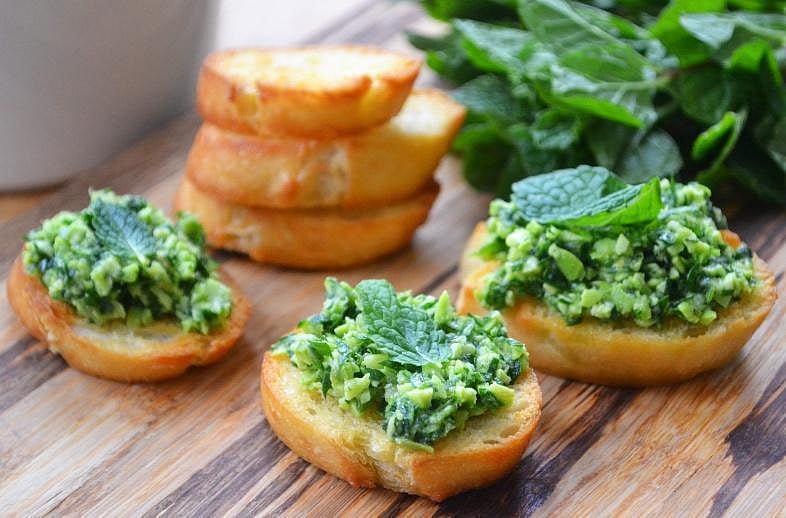 Pea and mint crostini on a wooden board