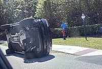 | Photo: AP/Jason Oteri : Golfer Tiger Woods stands by his overturned vehicle in Jupiter Island, Florida..