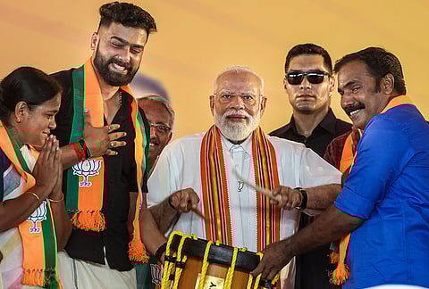 Prime Minister Narendra Modi plays 'Chenda', a traditional cylindrical percussion instrument from Kerala, during a public meeting, in Palakkad, Kerala. 