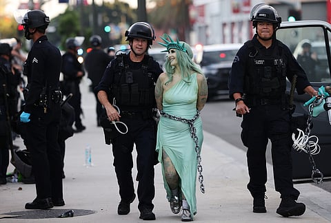 Police arrest a protestor dressed as the Statue of Liberty, in downtown Los Angeles after the "No Kings" rally.