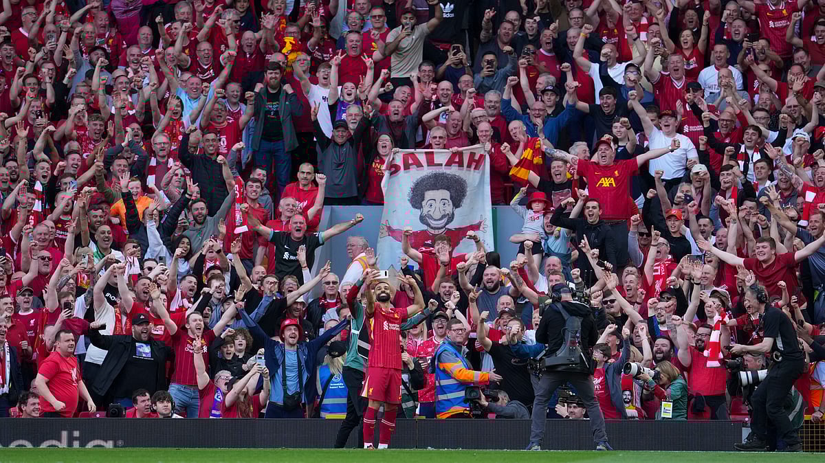 Liverpool's Mohamed Salah takes a selfie with a fans smartphone as he celebrates after scoring his side's fourth goal during the English Premier League soccer match between Liverpool and Tottenham Hotspur at Anfield in Liverpool, England, Sunday, April 27, 2025.  - | Photo: AP/Jon Super