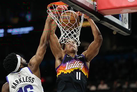 Phoenix Suns forward Oso Ighodaro (11) dunks against Utah Jazz guard Elijah Harkless during the first half of an NBA basketball game, in Phoenix. 