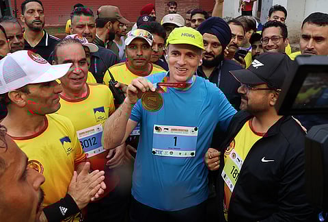 Jammu and Kashmir Chief Minister Omar Abdullah shows a medal during the 'Jammu Marathon 2026', in Jammu.