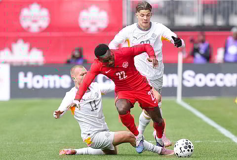 Canada's Richie Laryea, center, gets past Iceland's Jon Dagur Thorsteinsson, left, during an international friendly soccer match in Toronto.