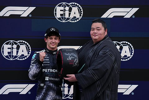 Mercedes driver Kimi Antonelli of Italy, left, poses with Japan's sumo wrestler Kotozakura after the qualifying session of the Japanese Formula One Grand Prix at the Suzuka Circuit in Suzuka, Japan.