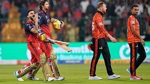 Royal Challengers Bengaluru's Virat Kohli, left, gestures to the fans as he walks out with teammate Tim David after winning the Indian Premier League cricket match against Sunrisers Hyderabad in Bengaluru, India, Saturday, March 28, 2026.