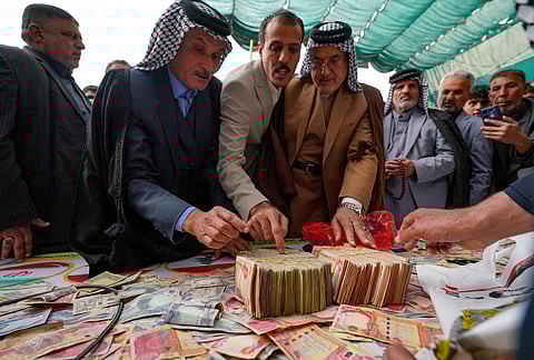 People donate money following a call by Grand Ayatollah Ali al-Sistani to support Iran and Lebanon during the war with the U.S. and Israel in Babylon, Iraq. 