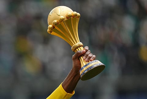 A Senegal player holds the Africa Cup of Nations trophy ahead of the international friendly soccer match between Senegal and Peru in Saint-Denis, outside of Paris.