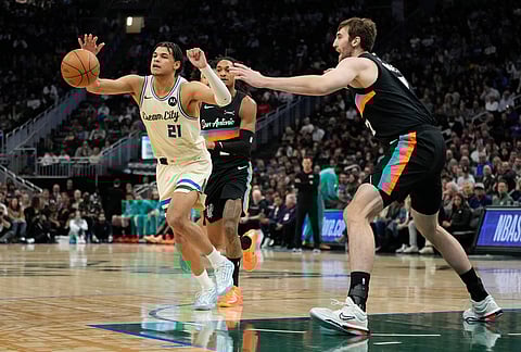 Milwaukee Bucks' Ousmane Dieng (21) controls the ball against San Antonio Spurs' Luke Kornet during the first half of an NBA basketball game in Milwaukee.
