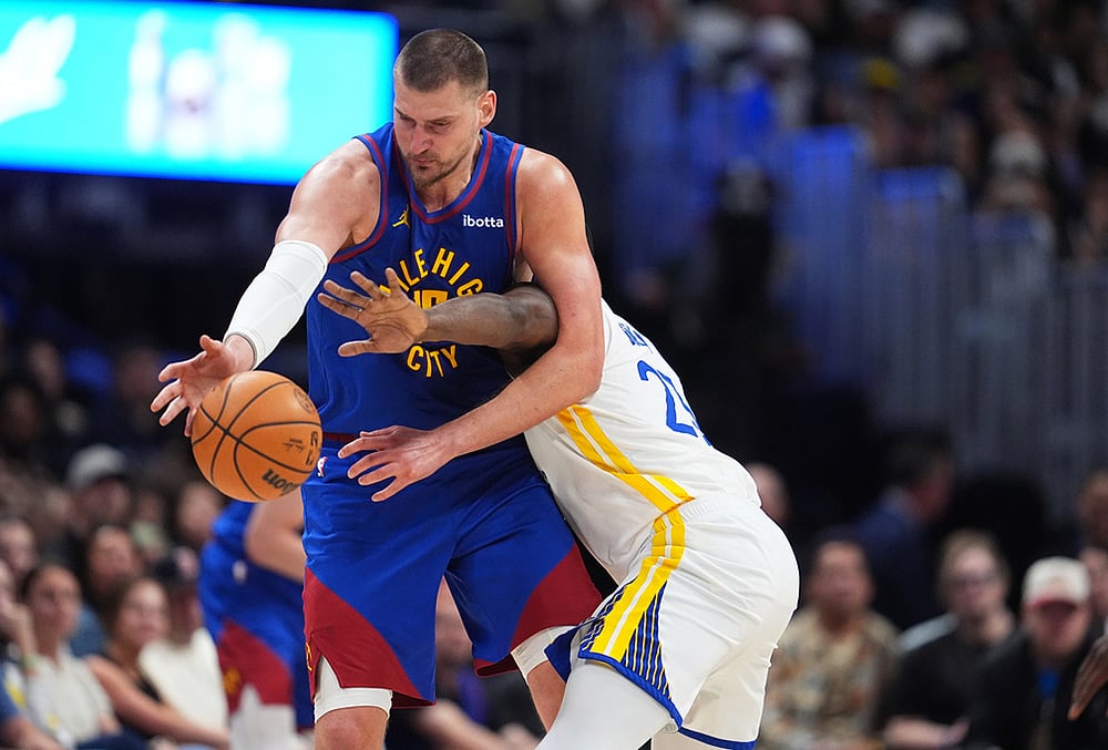 Denver Nuggets center Nikola Jokić, left, struggles to field a pass as Golden State Warriors forward Draymond Green defends in the second half of an NBA basketball game in Denver.  - | Photo: AP/David Zalubowski