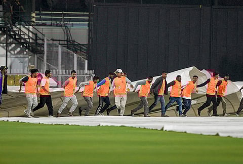 Ground staff covers the pitch during rain, before an Indian Premier League (IPL) 2026 T20 cricket match between Rajasthan Royals and Chennai Super Kings, at ACA Stadium, Barsapara, in Guwahati, Assam.