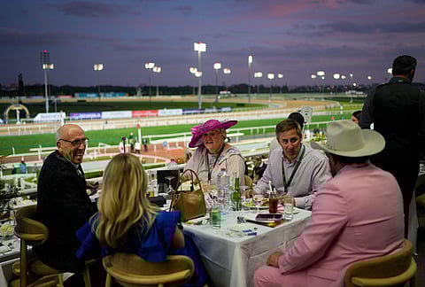 Racegoers dine in the grandstand during the Dubai World Cup at Meydan Racecourse in Dubai, United Arab Emirates.