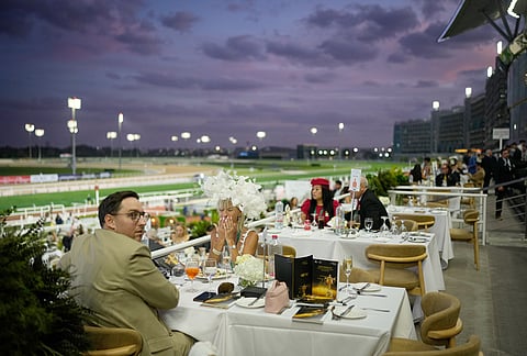 Racegoers dine at in the grandstand during the Dubai World Cup at Meydan Racecourse in Dubai, United Arab Emirates.