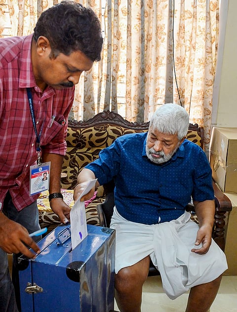 Bhaskara Kurup, 86, casts his vote as part of home voting at his residence ahead of the Kerala Legislative Assembly election, in Thiruvananthapuram.