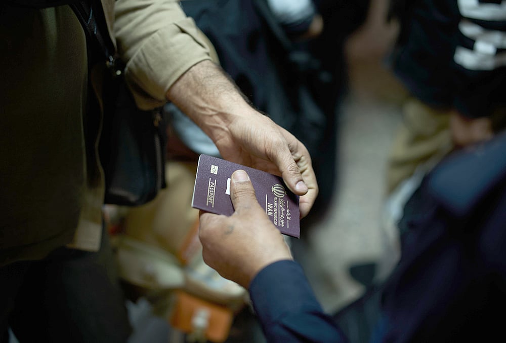 An Iraqi border police officer checks the passport of a man arriving from Iran as he crosses the Shalamcheh border crossing between Iran and Iraq, near Basra, Iraq.  - | Photo: AP/Leo Correa