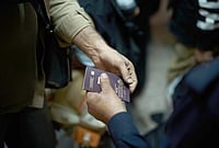 | Photo: AP/Leo Correa : An Iraqi border police officer checks the passport of a man arriving from Iran as he crosses the Shalamcheh border crossing between Iran and Iraq, near Basra, Iraq. 