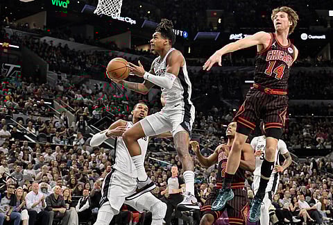 San Antonio Spurs guard Devin Vassell goes to the basket as he is guarded by Chicago Bulls forward Matas Buzelis (14) during the first half of an NBA basketball game, in San Antonio.