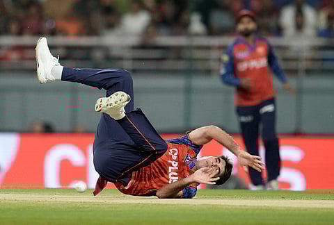 Punjab Kings' Xavier Bartlett loses balance after bowling a delivery during the Indian Premier League cricket match between Gujarat Titans and Punjab Kings in New Chandigarh.