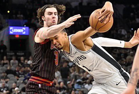 San Antonio Spurs center Victor Wembanyama (1) tangles with Chicago Bulls guard Josh Giddey, left, during the first half of an NBA basketball game, in San Antonio.
