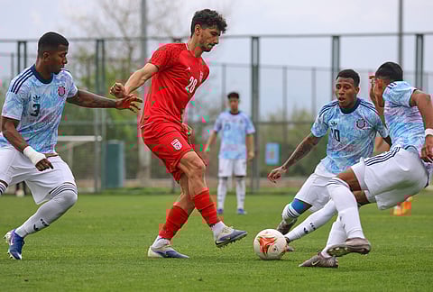 Iran's Amirmohammad Razaghinia, center, vies for the ball with Costa Rica's defenders during a friendly soccer match between Iran and Costa Rica, in Antalya, southern Turkey.