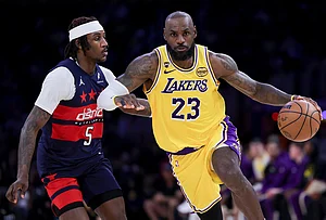 | Photo: AP/Ryan Sun : Los Angeles Lakers forward LeBron James, right, drives against Washington Wizards guard Jamir Watkins during the second half of an NBA basketball game in Los Angeles.