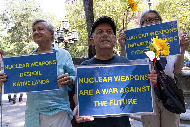 Members of New York Campaign To Abolish Nuclear Weapons (NYCAN) hold sunflowers and signs that read NUCLEAR WEAPONS ARE A WAR AGAINST THE FUTURE NUCLEAR WEAPONS DESPOIL NATIVE LANDS at a vigil in City Hall Park marking 80 years since the U.S. government s Trinity Test, the detonation of the first nuclear weapon on July 16, 1945 in the Tularosa Basin in New Mexico. - null